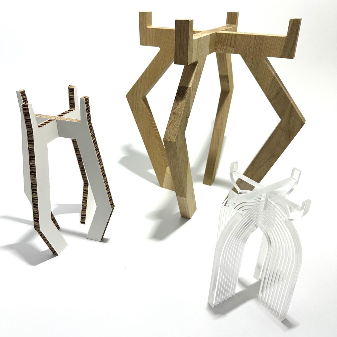 trois supports de forme géométrique en bois et plastique, de différentes couleurs.